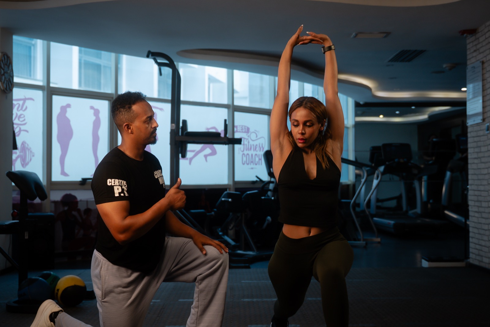 Coach Miki encouraging a client through a lunge exercise